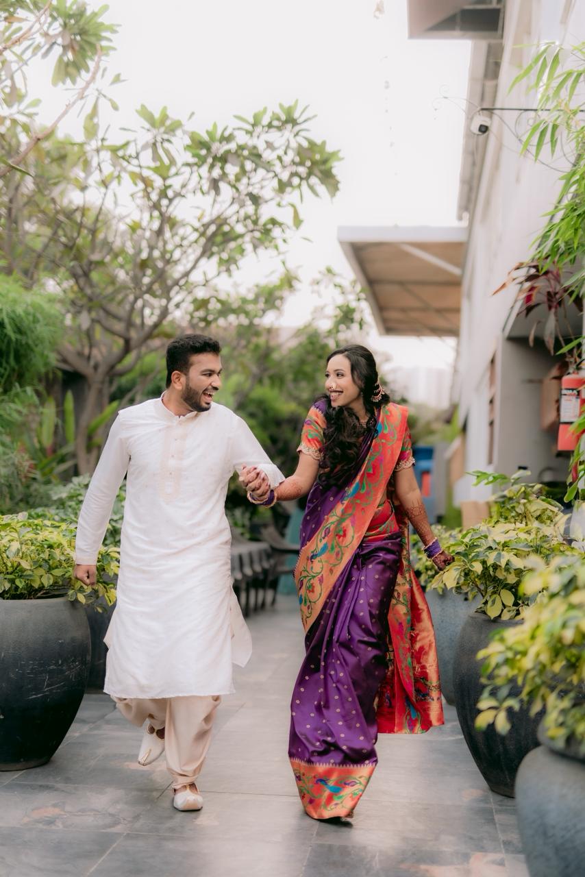 Couple walking hand in hand through a garden courtyard