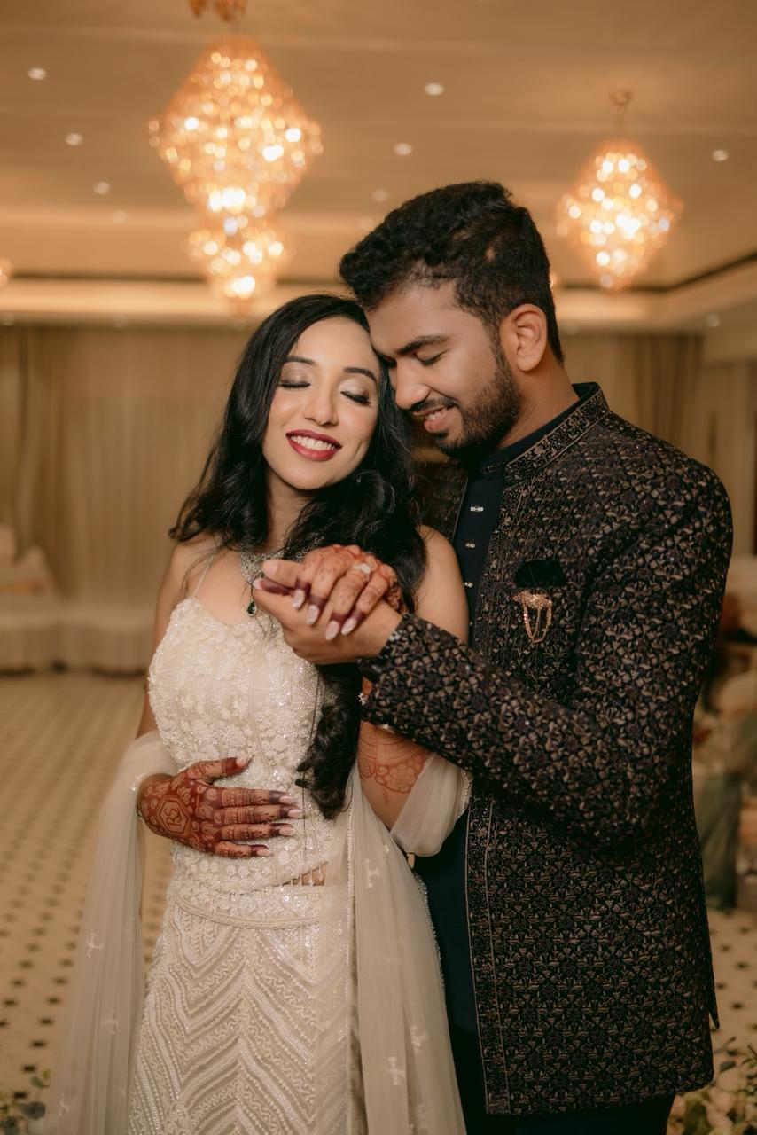 Couple admiring the ring under ballroom chandeliers